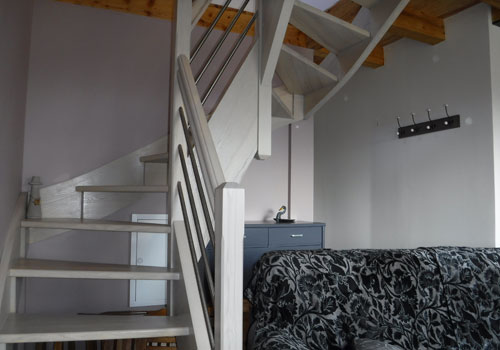 Vue de l'escalier situé dans le coin salon, menant aux chambres du gîte Lou Saltret en Lozère