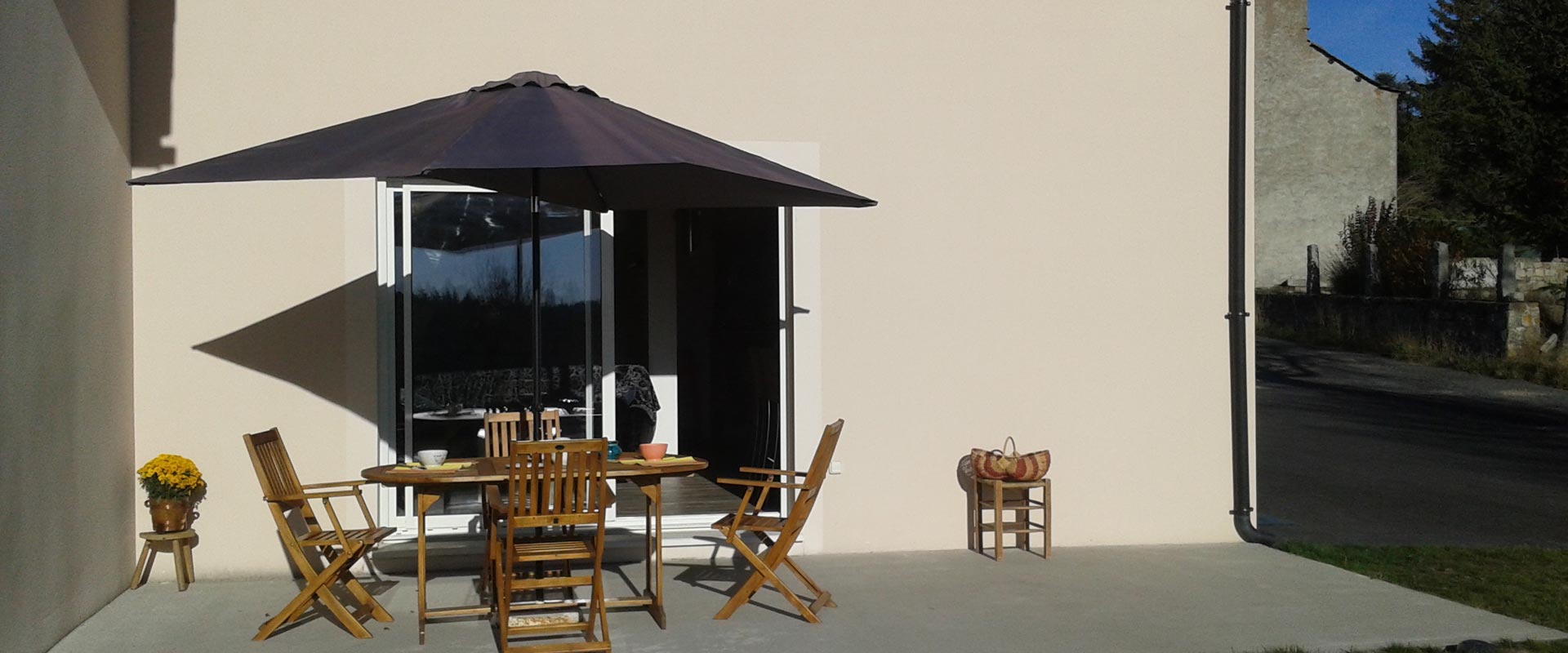 Aménagement extéreur, la terrasse avec salon de jardin teck + parasol du gîte Lou Saltret en Lozère